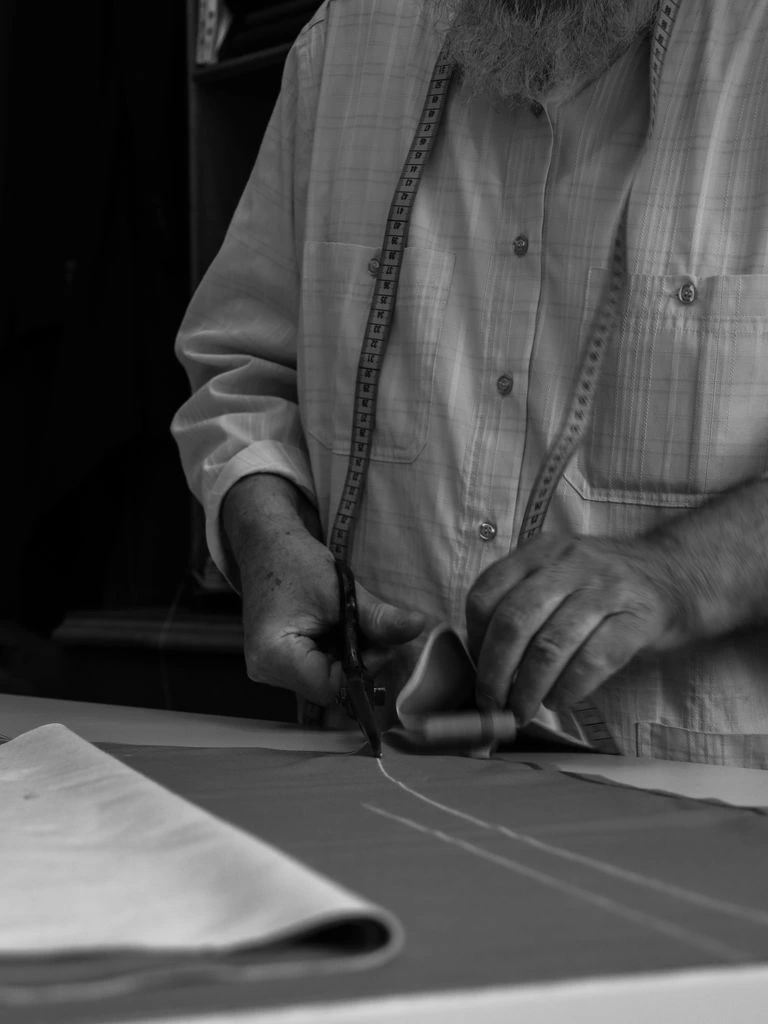 Hand-pad stitching on the chest canvas of a half-made jacket.
